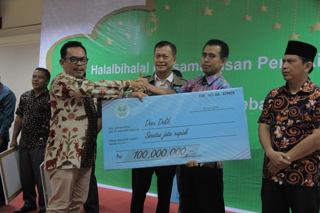 Asian Agri’s Regional Head of Riau, Omri Samosir, handed over the rewards to the village chiefs.